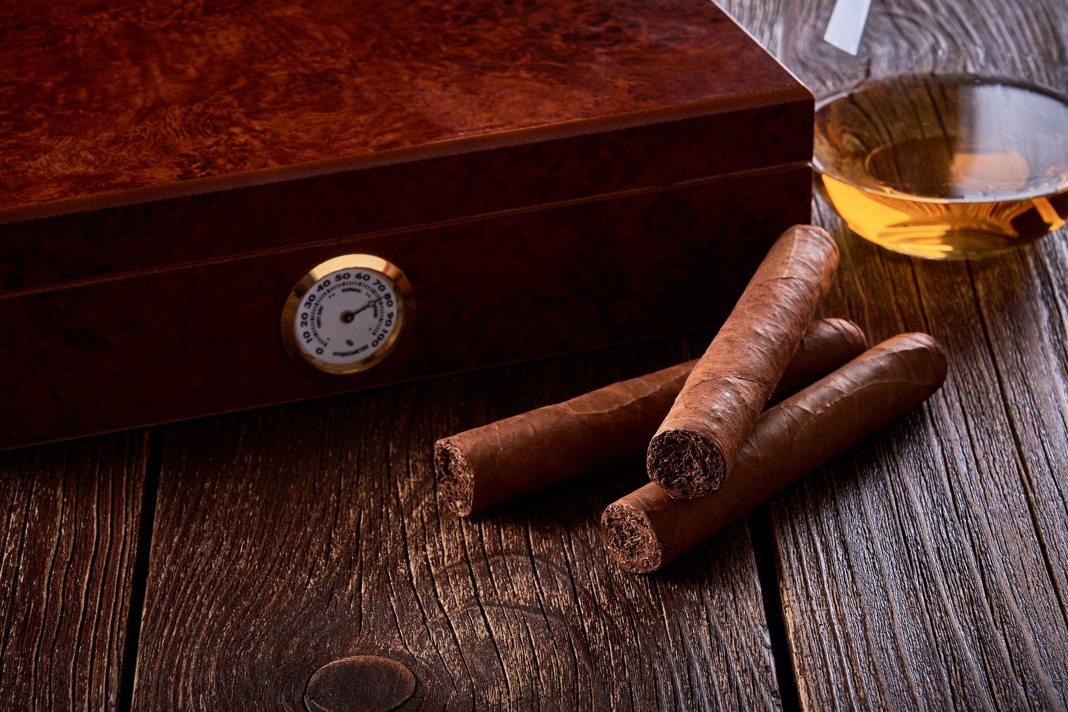 Premium cigars with whiskey on a wooden table